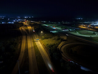 Cars speeding down highway at night, tracing light trails