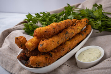 Potato dough sticks fried in oil. Served with parsley and sauce.