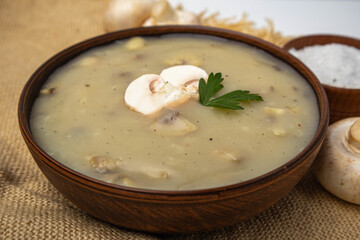 mushroom gravy in a clay bowl on a linen tablecloth
