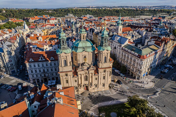 Beautiful view of St. Nicholas Church in Prague’s Old Town Square, surrounded by historic buildings and vibrant city life in the heart of the Czech capital.