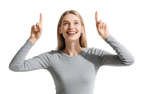 A joyful woman in a gray top is pointing upwards with both hands, showing a positive and cheerful expression.