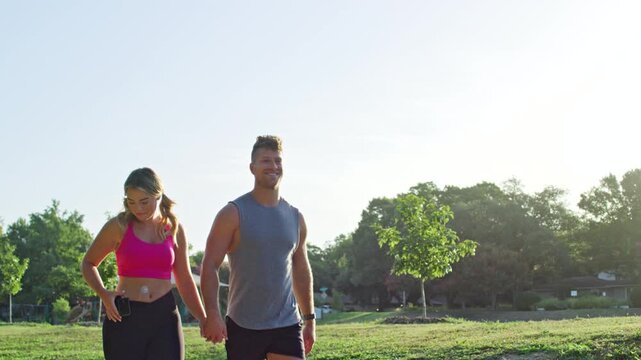 Woman walks through the park with her partner while monitoring her glucose levels with a device for diabetes.