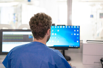 Doctor working on computer in hospital icu