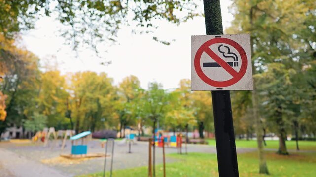 No smoking sign, Detailed closeup of no smoking sign close to playground with blurred swings