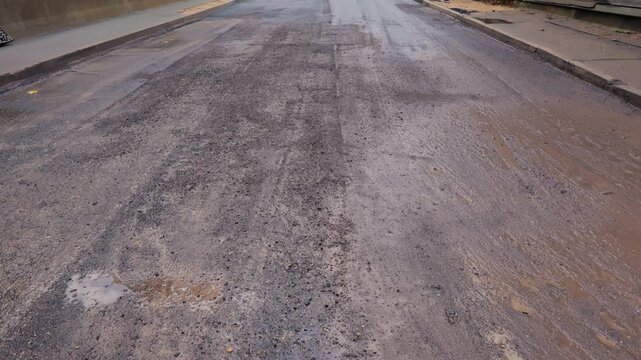 Wet asphalt with puddles and oil sheen, Recently rainwet asphalt with puddles and rut marks