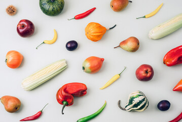 Assorted fresh vegetables and fruits on light background, colorful flat lay composition. Thanksgiving, harvest concept. Top view