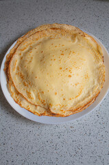 Stack of Homemade Crepes on White Plate, Top View — Thin Pancakes (Blini)
