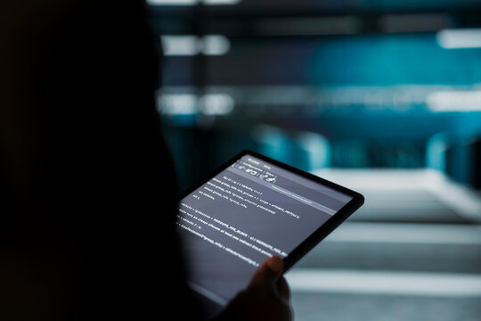 Close up of engineer using tablet in sustainable data center, implementing green technologies. IT expert working on energy efficient solutions to reduce server farm carbon footprint
