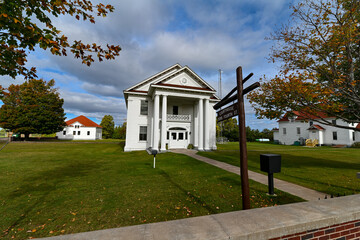 Historic Keweenaw County Courthouse in Eagle River, Michigan with autumn trees and wooden signpost