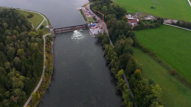 Herbstliche Luftlandschaft der Lechstaustufe 15 in Landsberg. Drohnenperspektive zeigt Renovierung, Flussbau und Fischtreppen fuer wandernde Fische. Renovation, river engineering, and fish ladders