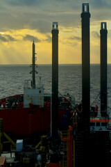 A semi-submersible heavy lift ship underway at sea under dramatic sky