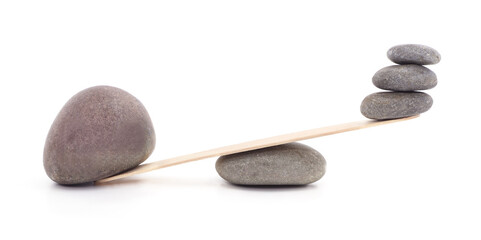 Balance concept with stacked stones on wooden plank isolated on white.