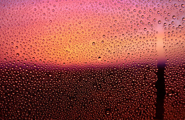 水滴のついた窓越しの風景　夕暮れ　エモーショナル　ノスタルジック　雨上がり　湿気　背景