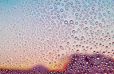 水滴のついた窓越しの風景　夕暮れ　エモーショナル　ノスタルジック　雨上がり　湿気　背景