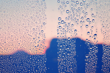 水滴のついた窓越しの風景　夕暮れ　エモーショナル　ノスタルジック　雨上がり　湿気　背景