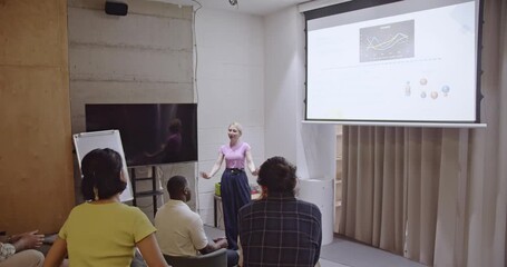Multiracial business team listens attentively as a female executive delivers a presentation in a modern office space. - Powered by Adobe