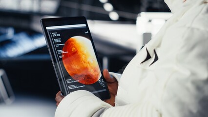 Cosmonaut ensuring operational readiness during mankind survival expedition to Mars. Upbeat astronaut navigates to red planet, doing human expansion in space to advance scientific knowledge