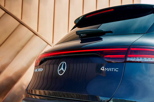 The rear of a dark blue Mercedes EQC 400 is featured with its re