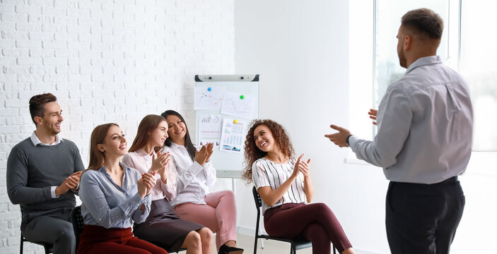 Colleagues listening to speaker at business meeting in office