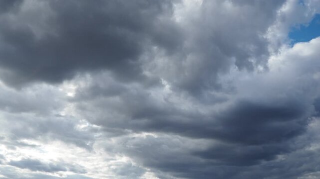 A blanket of dark clouds envelops the skyline, signaling an impending storm. The atmosphere becomes tense as the wind picks up and evening sets in. Real time slow motion video