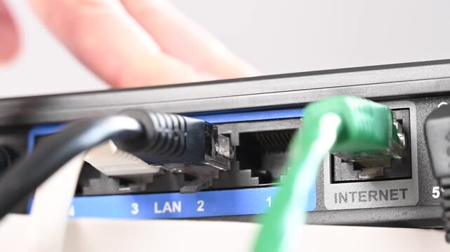 Woman pulling cable out of router. 