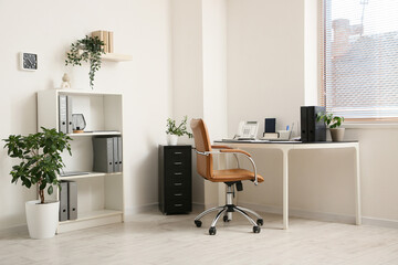 Comfortable workplace with leather brown chair in office