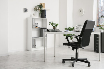 Comfortable workplace with black chair in interior of room, closeup
