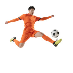 A male soccer player in an orange uniform is performing a dynamic kick on a soccer ball.