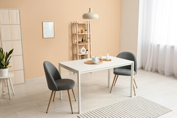 Interior of dining room with table and chairs near beige wall