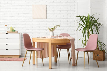 Table and chairs near white brick wall in interior of dining room