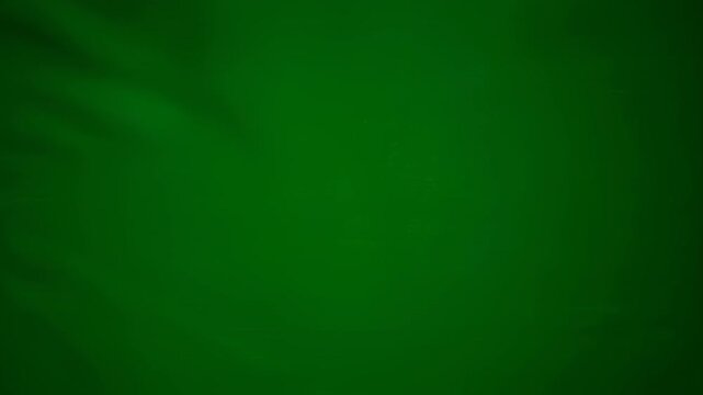 A uniform, softly illuminated deep green background with subtle textural variations and gentle light shifts providing a versatile chroma key surface advertising, backdrop, elegant