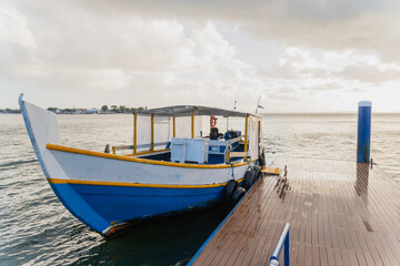 Wooden boat next to a pier on a cloudy day
