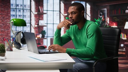 Black teleworker shaking his leg under the desk and acting unsettled, feeling anxious and tense...