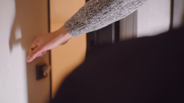 Close up of hand turning door handle while opening door to step outside then closing it back, showing everyday home routine with focus on human gesture