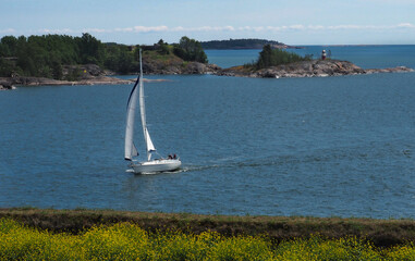 Sailboat sailing through islands in the archipelago of Helsinki, Finland. 