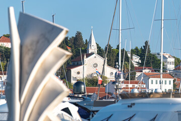 Rogoznica, Croatia - October 10, 2022: White church on the hilltop dominating the marina in Rogoznica