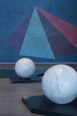 Contemporary geometric art installation with marble spheres and colorful abstract wall design in modern gallery interior. Minimalist composition and clean lines.
