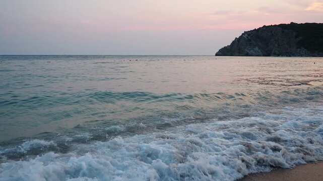 Soft morning light glimmers on the Adriatic waters at Canj beach, Montenegro. Waves caress the sandy shore, creating a serene atmosphere for relaxation and reflection as the day begins