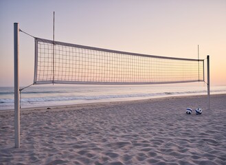 Beach Volleyball Net with Balls at Sunset