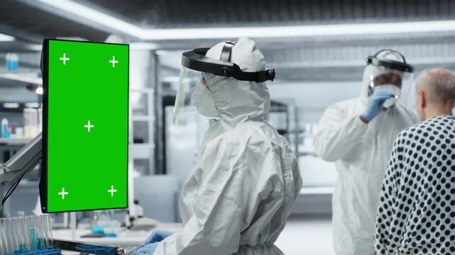 Medic looks at vertical green screen on monitor and observes patient reactions to antiviral treatment in a controlled laboratory setting. Vaccine development progress in prevention center. Camera B.