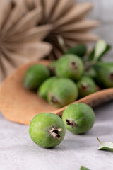 Fresh green feijoa fruit on a neutral surface