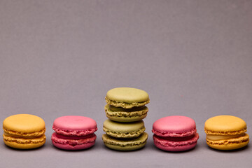 Four macarons assorted colors on gray background