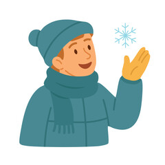 Man in winter clothes with hat and scarf catching snowflake, smiling and enjoying winter.
