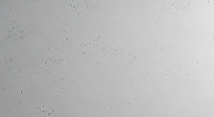 Closeup of a textured light gray wall with small irregular indents and subtle surface variations