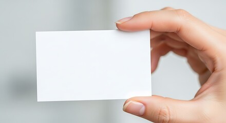 Obraz premium A Hand Holds a Blank White Business Card Ready for Information and Contact Details