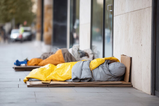 A homeless man sleeping on the street.