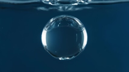 Water Bubbles Rising and Merging in Water on a Blue Background