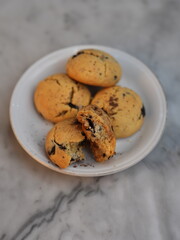 Golden cookies with melty chocolate, one broken to reveal soft interior