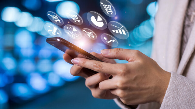Person using smartphone with e commerce icons hovering above against a blurred blue background - Powered by Adobe