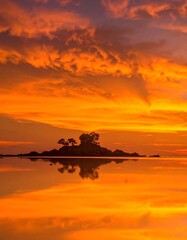 Vibrant sunset over a calm sea, island silhouetted